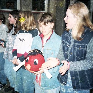 Group of teens holding toy in indoor setting.