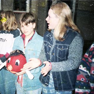 Group of teens holding toy in indoor setting.