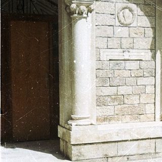Historic stone courtyard with arched colonnade and fountain.