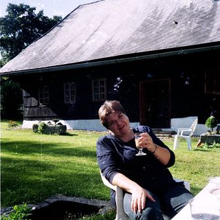 Man relaxing outdoors with wine glass.