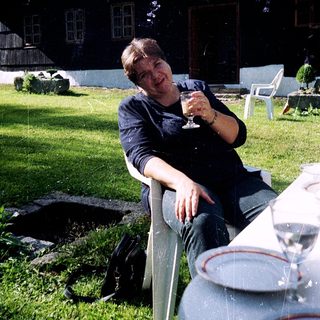 Man relaxing outdoors with wine glass.