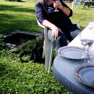 Man relaxing outdoors with wine glass.