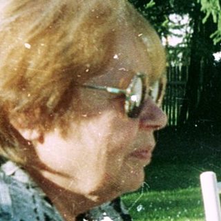 Three elderly women enjoying outdoor meal together.