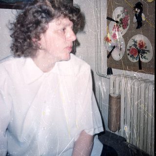Person standing near decorative Japanese folding fans.