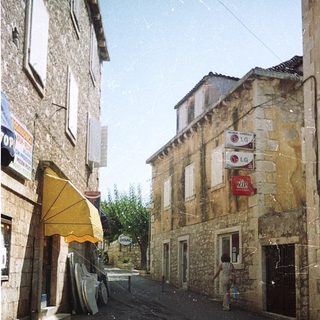 Quaint European village street with stone buildings.