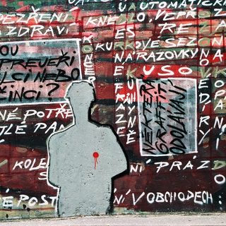 Graffiti mural with Czech political slogans and silhouettes.