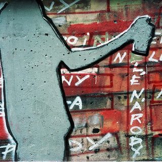 Urban graffiti with Czech text and hammer symbol.