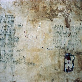 Graffiti and inscriptions on a weathered wall.