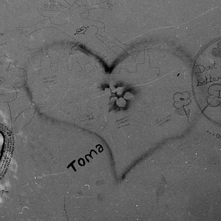 Graffiti-covered wall with heart and messages.