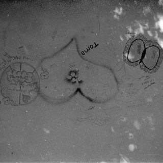 Heart-shaped graffiti with personal messages on wet surface.