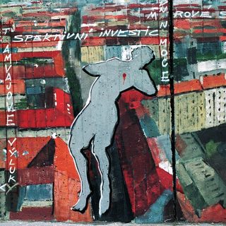 Urban scene with falling figure amid text about Prague's old town.
