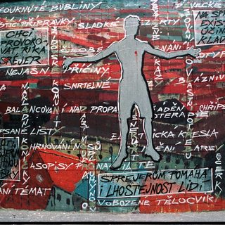 Vibrant mural with Czech text and silhouette of a balancing figure.