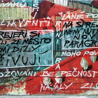 Graffiti protest message in Czech on damaged wall.