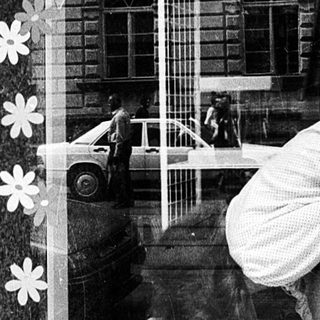 Window display decoration with floral cutouts and a mannequin in a shop window.