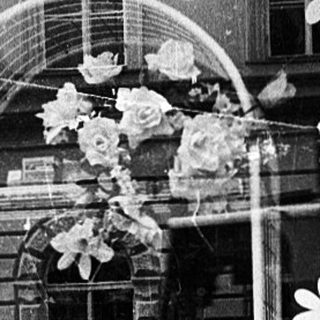 Window display decoration with floral cutouts and a mannequin in a shop window.