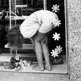 Window display decoration with floral cutouts and a mannequin in a shop window.