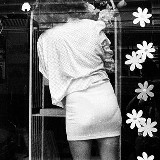 Person decorating school window display with flowers.