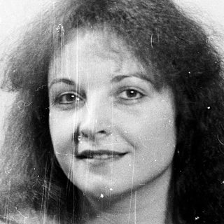 Wet-haired woman smiling in black-and-white photo.