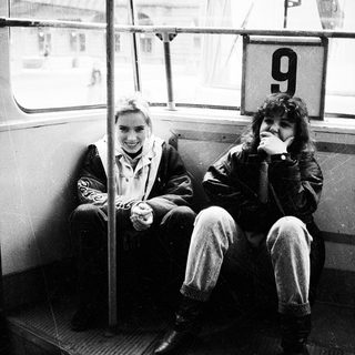 Two people smiling inside a numbered tram.