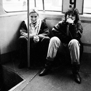 Two people smiling inside a numbered tram.