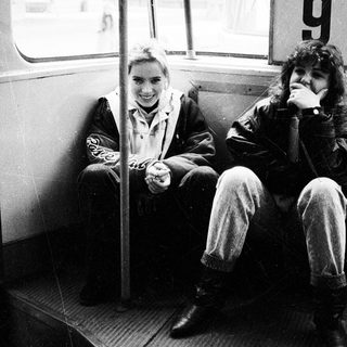 Two people smiling inside a numbered tram.