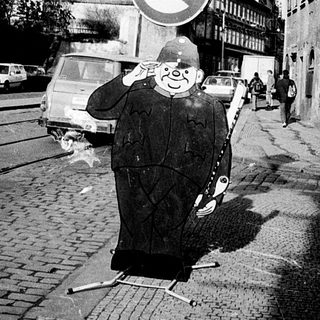 Man crossing street with traffic signs in background.