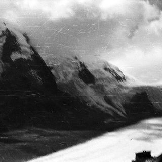 Majestic mountain peaks with snow and clouds.