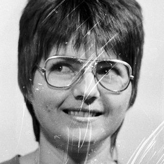 Wet-haired woman smiling with glasses.