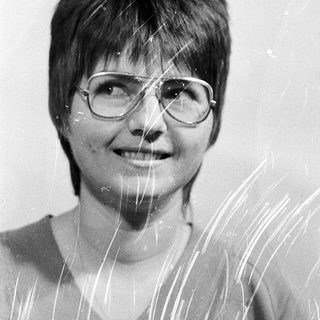 Wet-haired woman smiling with glasses.