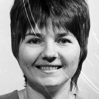 Smiling woman with short hair in casual blouse.