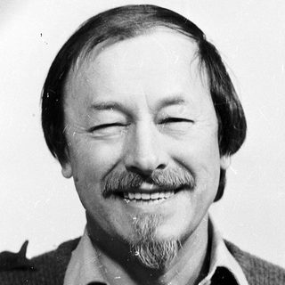 Smiling man with mustache and beard.