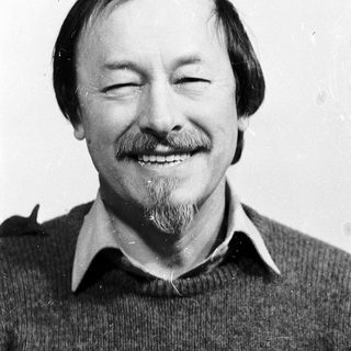 Smiling man with mustache and beard.