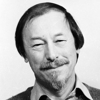 Man with mustache and beard smiling.