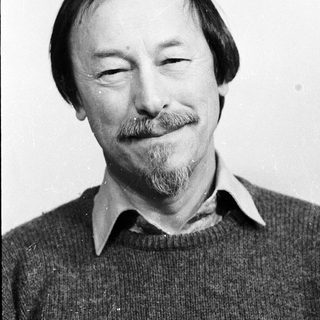 Man with mustache and beard smiling.