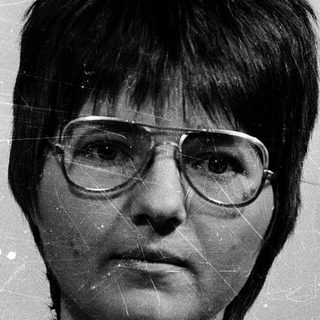Black-and-white portrait of a woman wearing glasses.