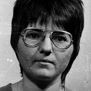 Black-and-white portrait of a woman wearing glasses.