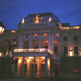 Neoclassical building illuminated at night.