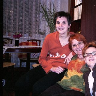 Three people posing happily indoors together.