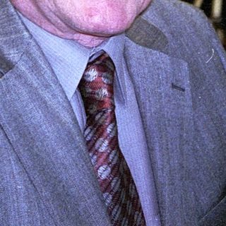 Elderly man smiling indoors at a café.
