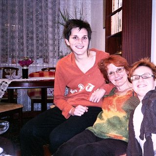 Three women smiling indoors together.