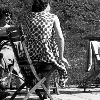 People relaxing outdoors near a building.