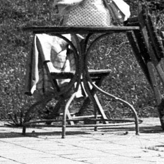 People relaxing outdoors near a building.