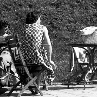 People relaxing outdoors near a building.