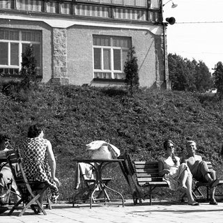 People relaxing outdoors near a building.