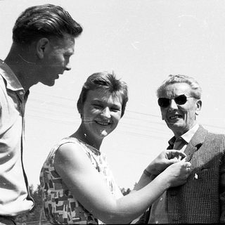 Four people posing outdoors in mid-20th-century attire.