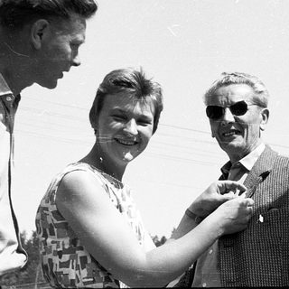 Four people posing outdoors in mid-20th-century attire.