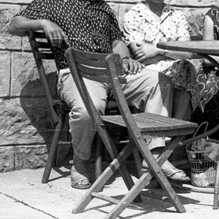 Four people sitting together outdoors at a café table.
