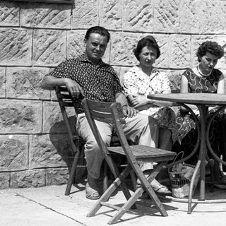 Four people sitting together outdoors at a café table.