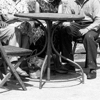 Four people sitting together outdoors at a café table.