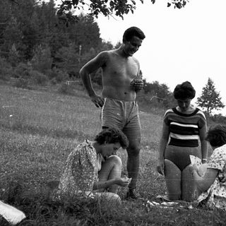 Family picnic in outdoor grassy field.